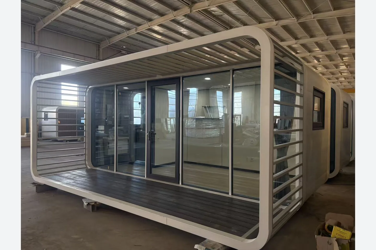 white 20ft prefab apple cabin with rounded veranda frame and glass wall