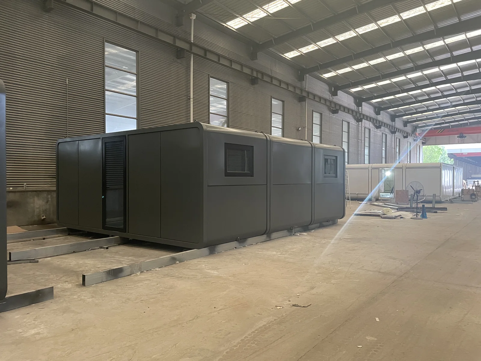 dark gray prefab Apple Pod side view with rounded shell and compact windows