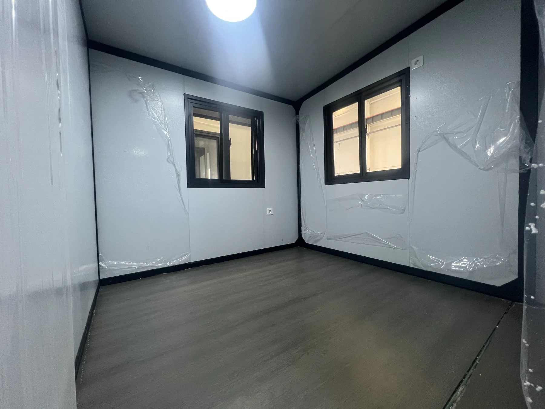 finished interior room of a 20ft expandable house with windows lighting and flooring