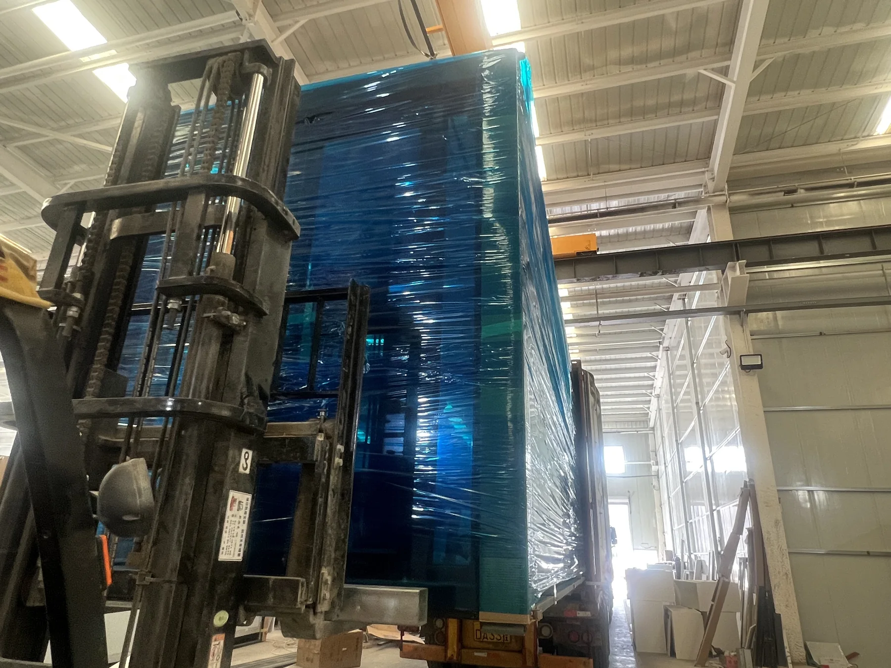 20ft folding container house protected with blue export wrapping during factory loading