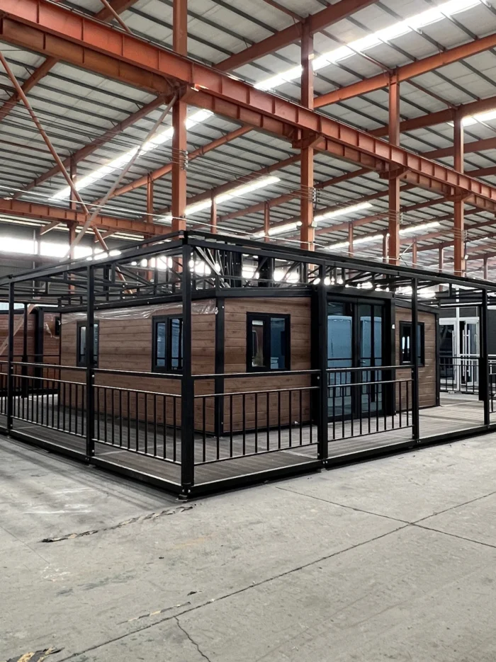 20ft Folding House with Wraparound Veranda - Factory View 20ft expandable folding house with wraparound veranda and black steel railing factory view