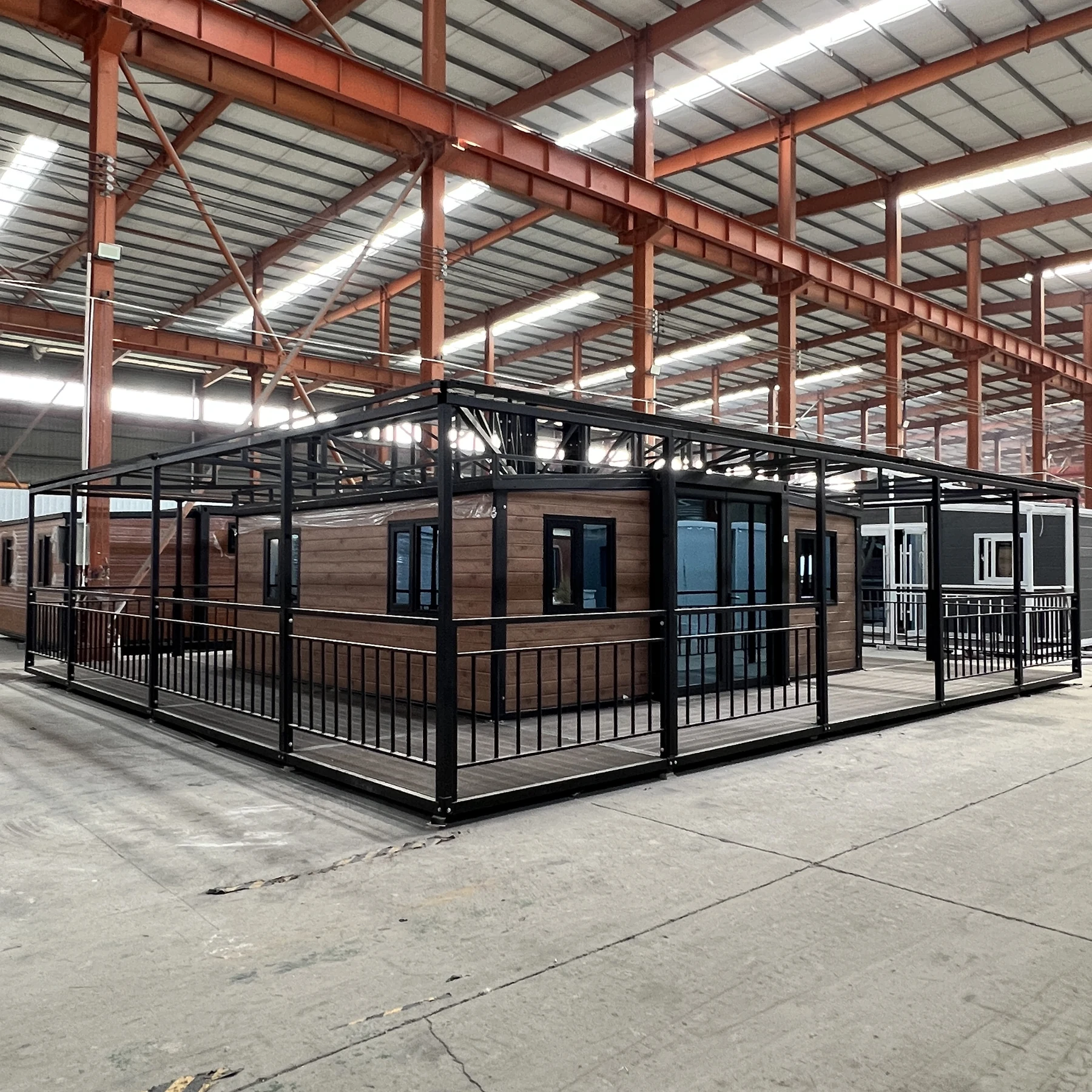 20ft expandable folding house with wraparound veranda and black steel railing factory view