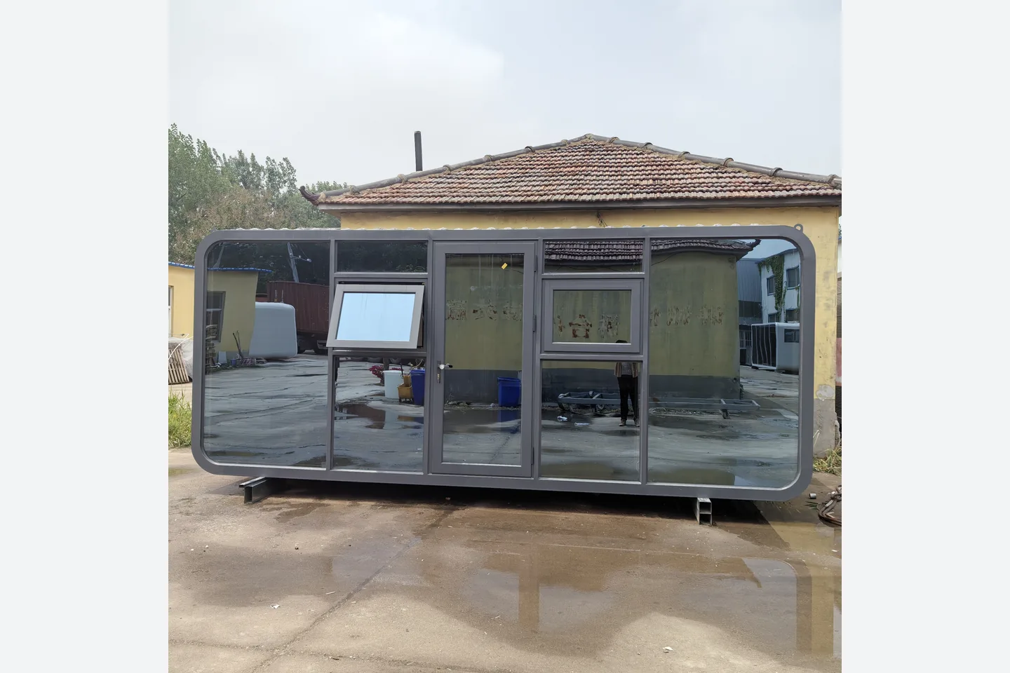 front view of a gray 20ft apple pod with glass wall and awning windows