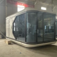factory-built 20ft Apple pod with rounded white shell and dark glass
