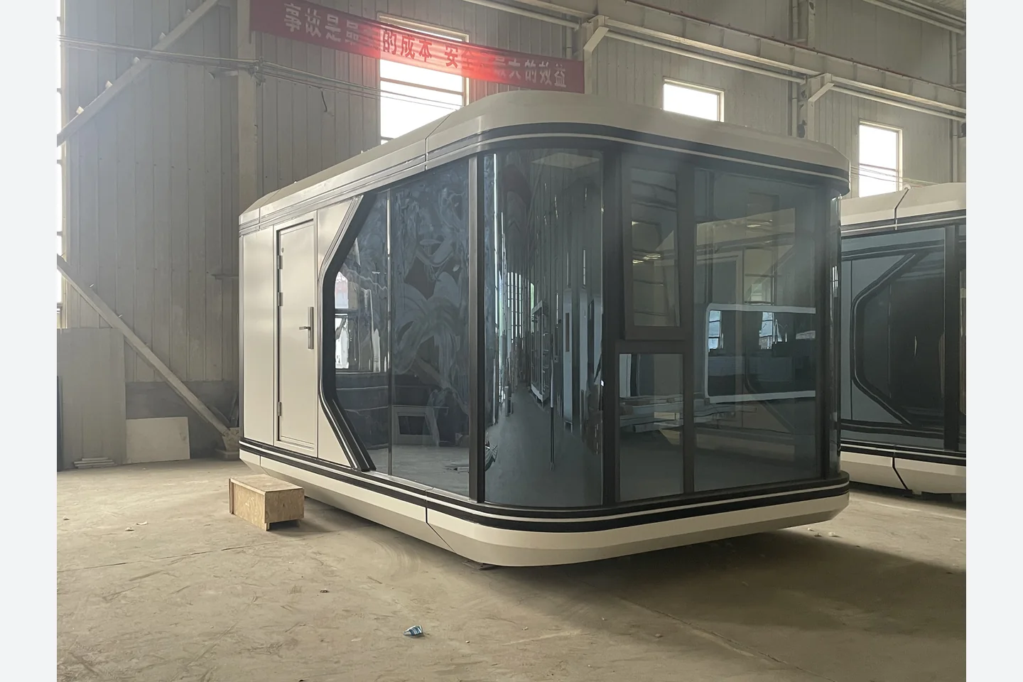 factory-built 20ft Apple pod with rounded white shell and dark glass