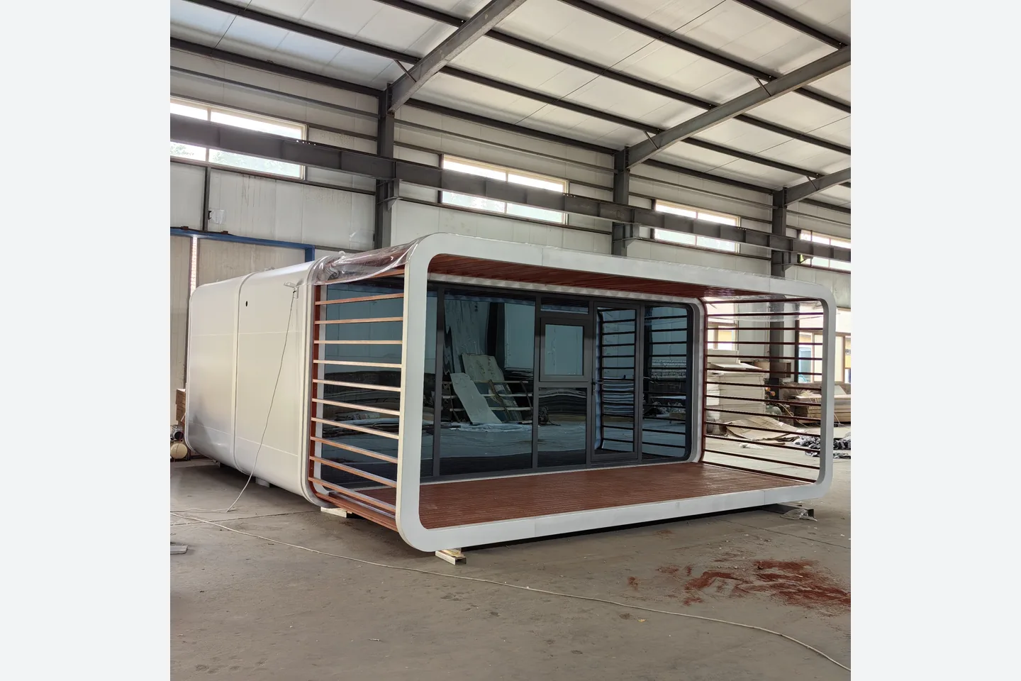 front view of 20ft prefab Apple Pod with panoramic glass and wood-look balcony