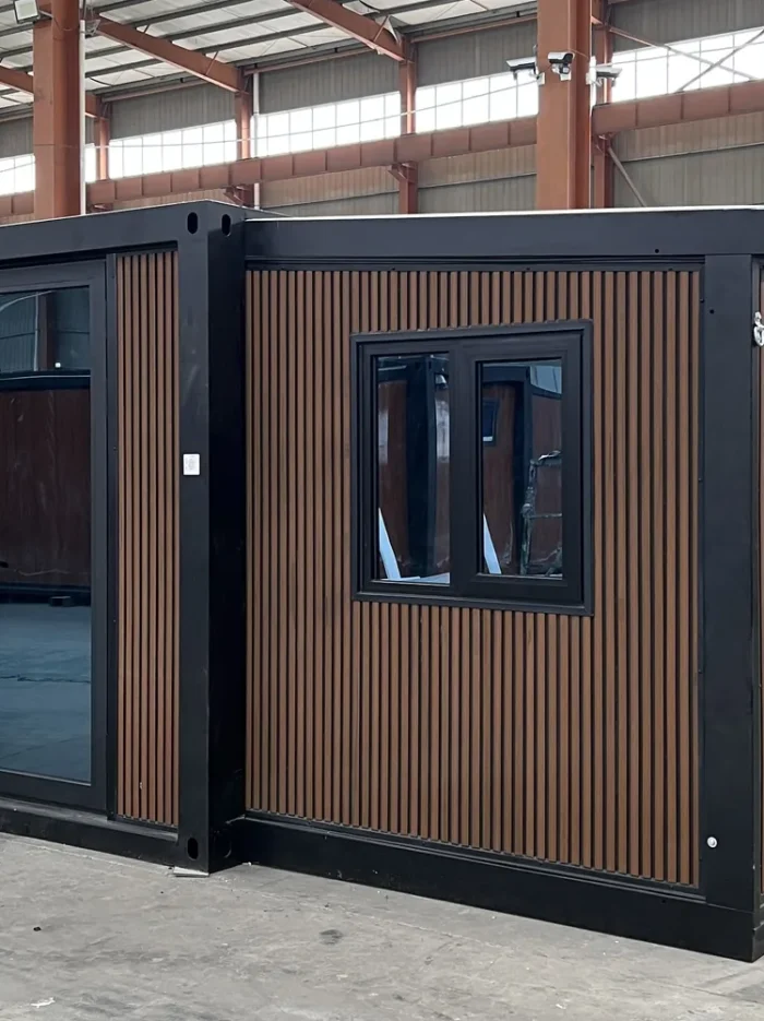 20ft Wood Grain Expandable Container House - Factory View 20ft wood grain expandable container house with black frame and vertical fluted exterior cladding