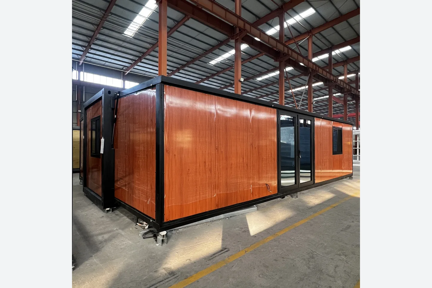 30ft double wing prefab home with red wood grain panels and glazed entrance