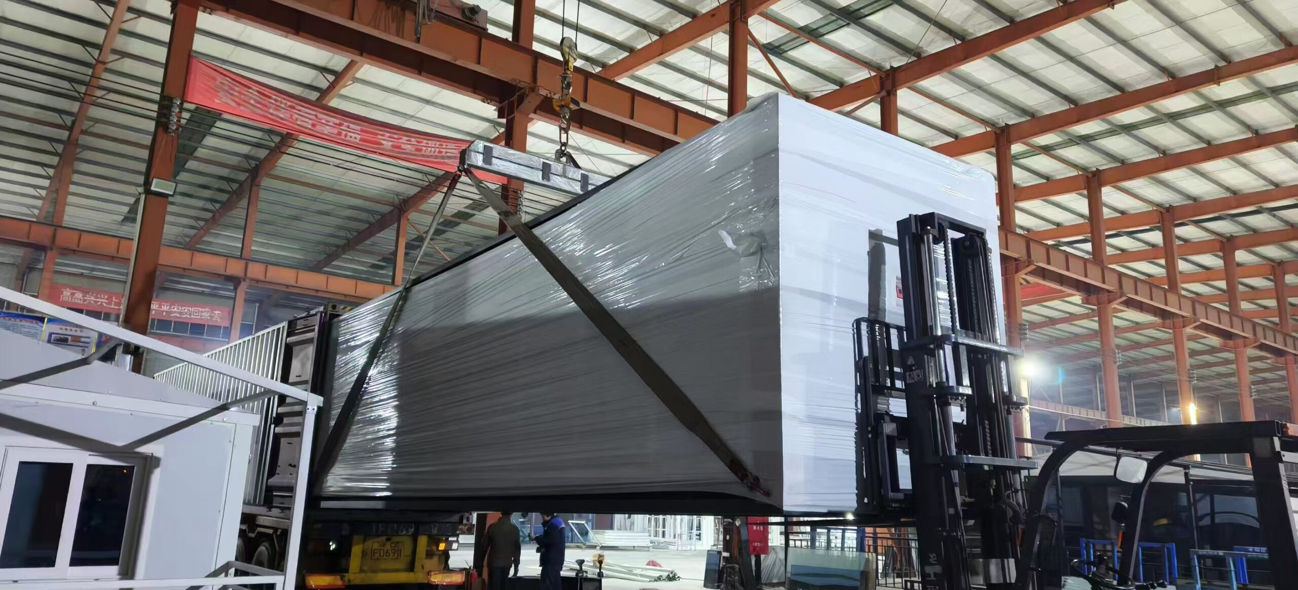 Factory loading a 30FT expandable house into an export container