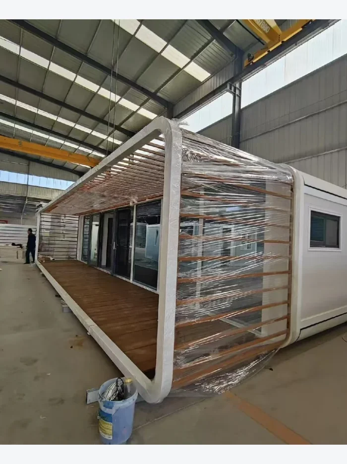 40ft Apple Cabin with Full-Length Pergola and Veranda 40ft white Apple Cabin with full-length covered pergola and wood-look veranda in factory