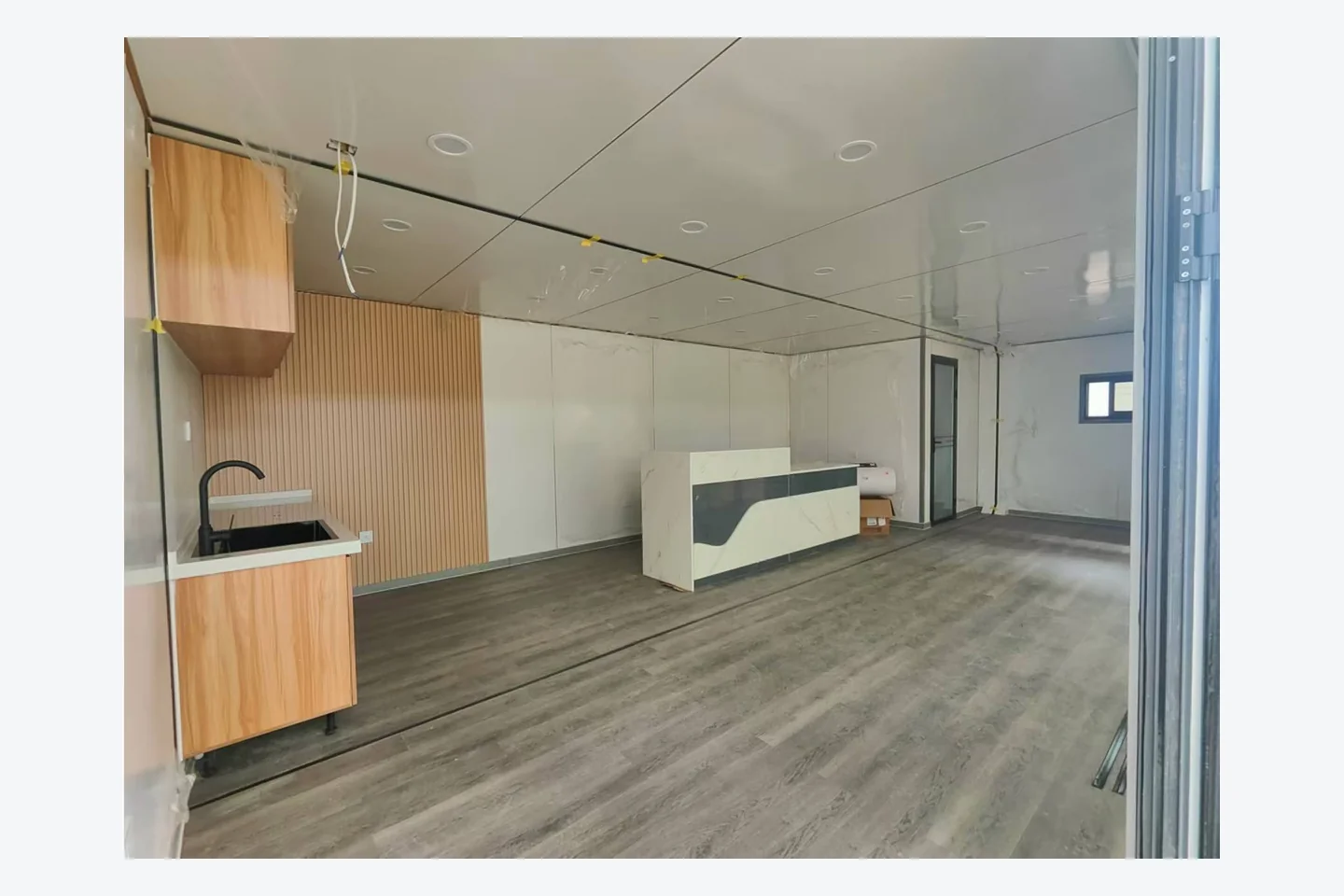 open-plan interior of a 40ft Apple Cabin with wood-look kitchen cabinets and island counter