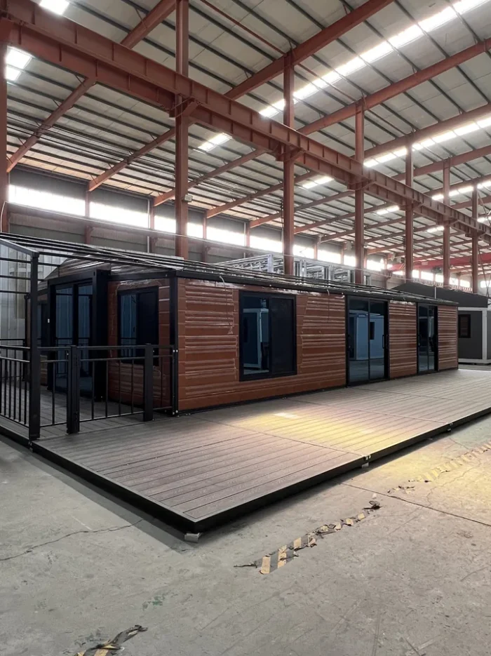 40ft Wood Grain Expandable House with Large Deck - Factory View 40ft wood grain expandable container house with black frame and full length front deck