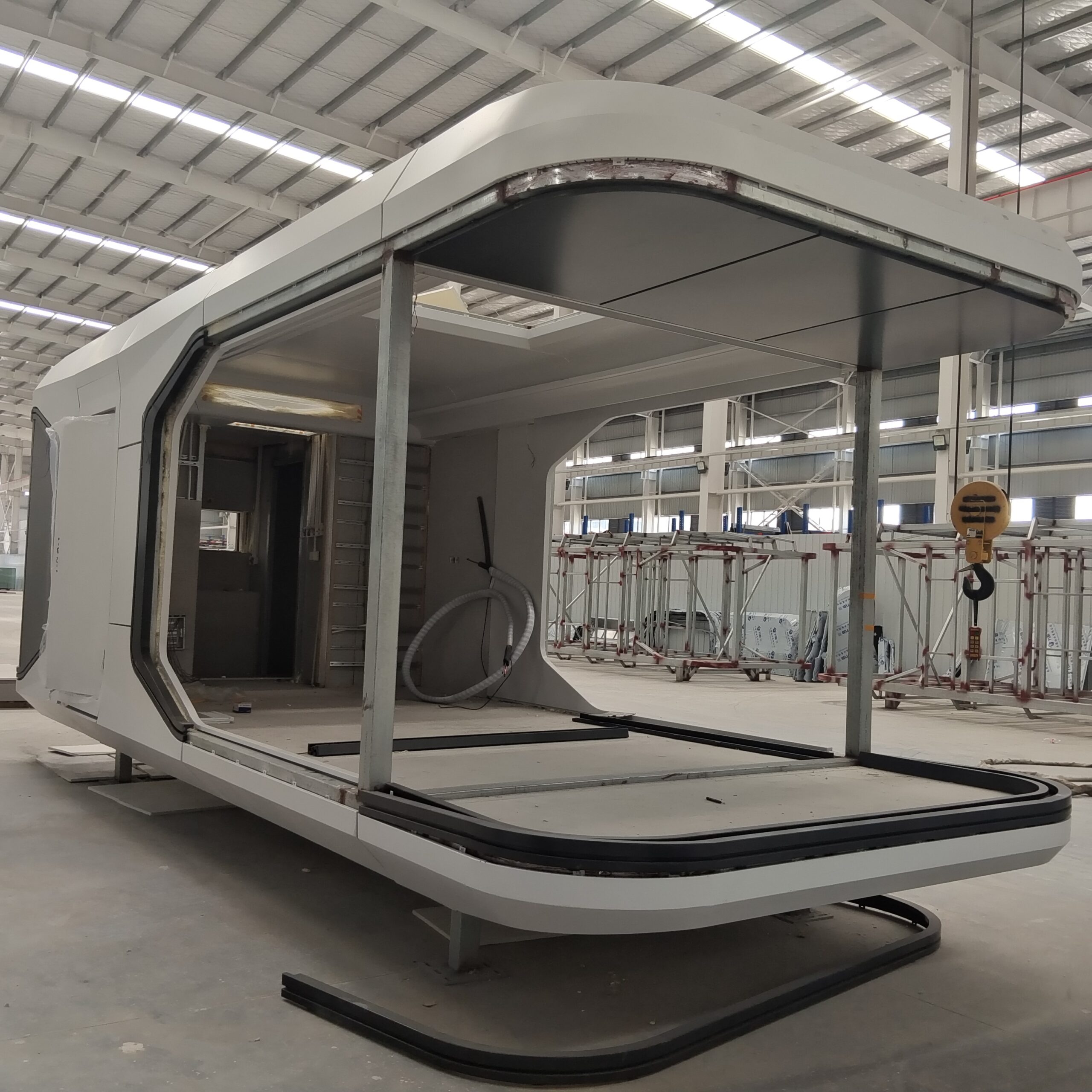 multiple white prefab Space Capsule Houses arranged inside the factory