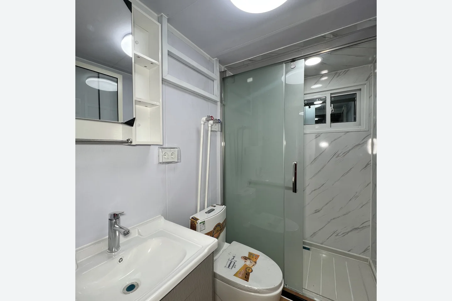 compact bathroom with shower toilet basin and mirror in a 20ft prefab house