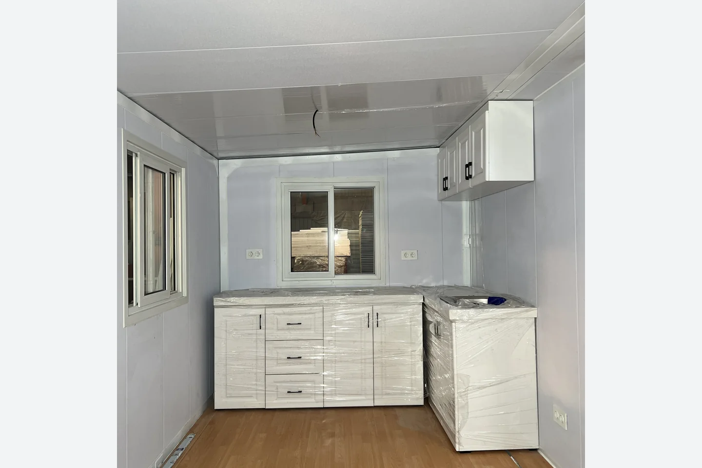 compact fitted kitchen cabinets and sink inside a 20ft expandable house