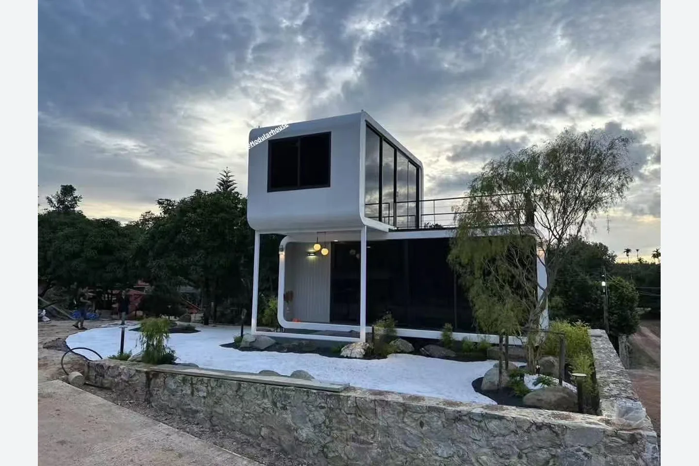 two floor modular apple cabin with black guardrails and roof deck