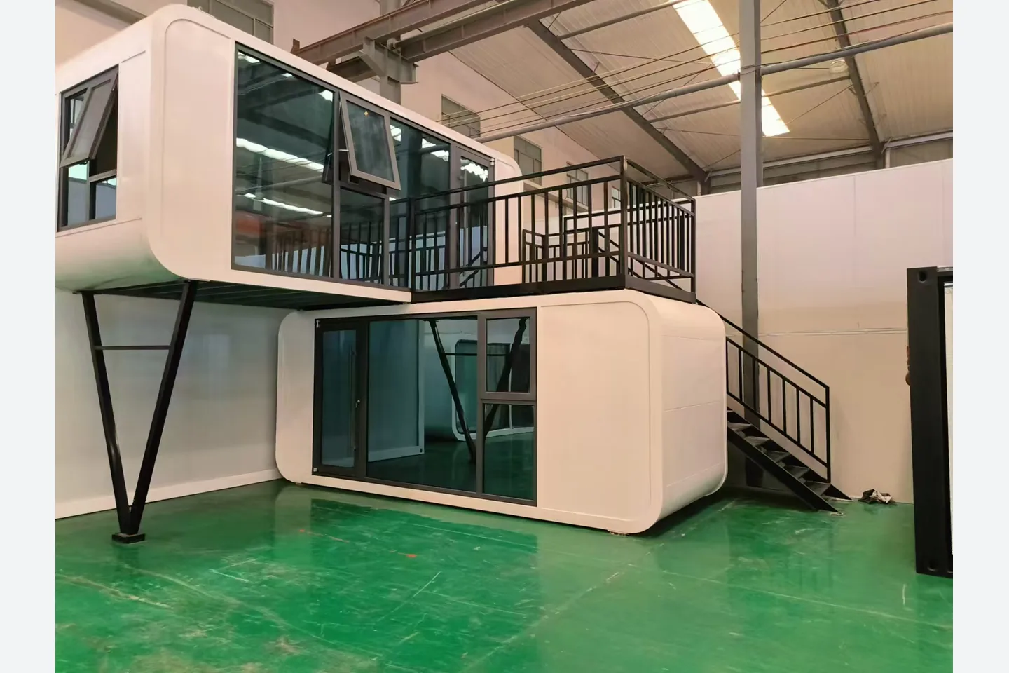 factory view of stacked 20ft apple cabin modules with steel supports staircase and terrace