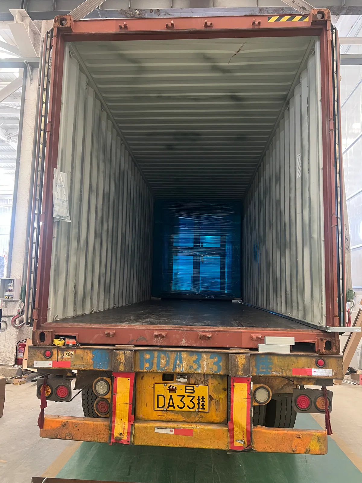Expandable prefab house positioned inside an export container bound for the United States