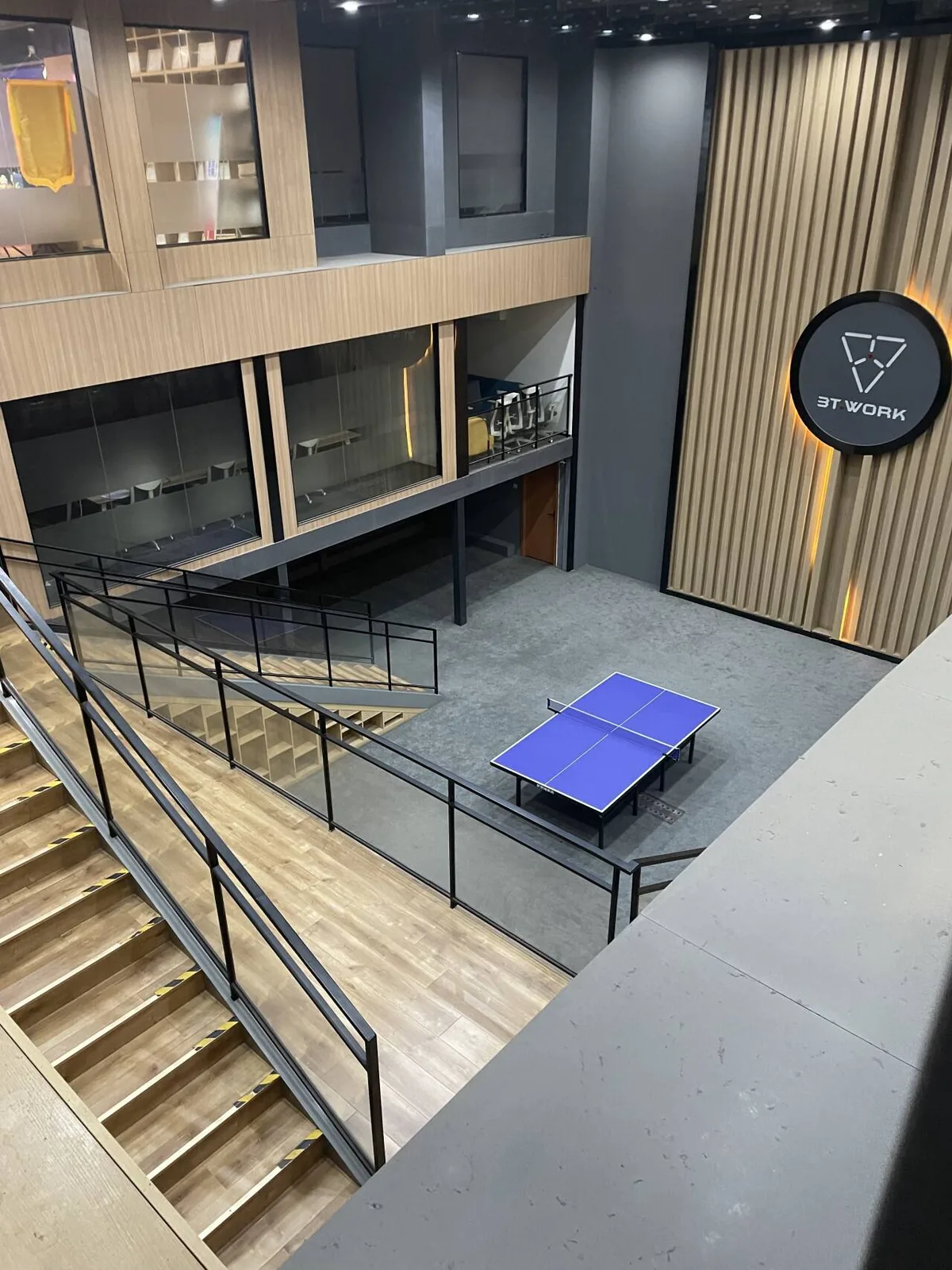 Modern office atrium with glass meeting rooms and collaboration space